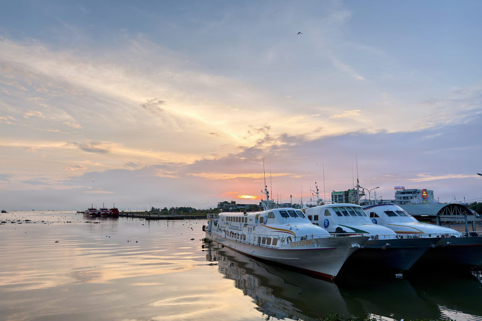 Rạch Giá at sunset, and kites over the field by the waterfront.